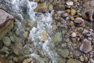 Azgın nehirdeki su. Taşların ve suyun güzel doğal arka planı. Berrak su ve hızlı nehir dokusu. Metin eklemek için arka plan. Turizm ve seyahat.