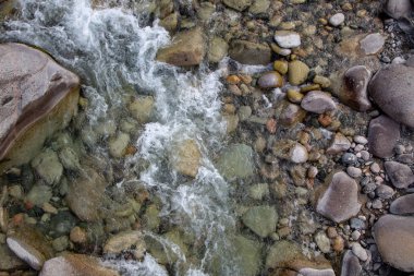 Azgın nehirdeki su. Taşların ve suyun güzel doğal arka planı. Berrak su ve hızlı nehir dokusu. Metin eklemek için arka plan. Turizm ve seyahat.