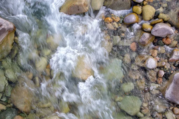 De l'eau dans la rivière montagneuse. Beau fond naturel de pierres et d'eau. Texture d'eau claire et rivière rapide. Contexte pour insérer du texte. Tourisme et voyages . — Photo