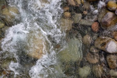 Azgın nehirdeki su. Taşların ve suyun güzel doğal arka planı. Berrak su ve hızlı nehir dokusu. Metin eklemek için arka plan. Turizm ve seyahat.