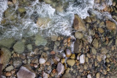 Azgın nehirdeki su. Taşların ve suyun güzel doğal arka planı. Berrak su ve hızlı nehir dokusu. Metin eklemek için arka plan. Turizm ve seyahat.