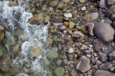 Azgın nehirdeki su. Taşların ve suyun güzel doğal arka planı. Berrak su ve hızlı nehir dokusu. Metin eklemek için arka plan. Turizm ve seyahat.