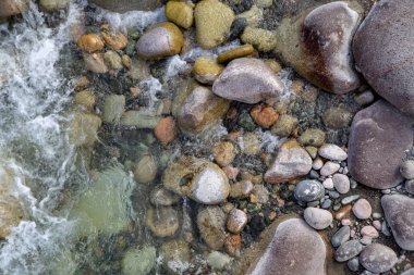Azgın nehirdeki su. Taşların ve suyun güzel doğal arka planı. Berrak su ve hızlı nehir dokusu. Metin eklemek için arka plan. Turizm ve seyahat.