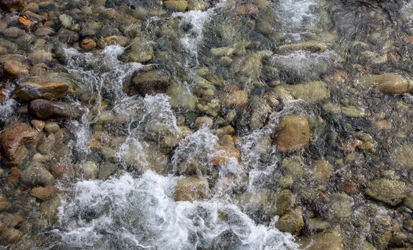 Víz a hegyen tomboló folyón. Gyönyörű természeti hátteret a kövek és a víz. Textúra tiszta víz és gyors folyami. Háttér a szöveg beszúrásához. Idegenforgalom és utazás. — Stock Fotó