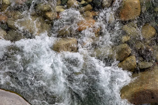 Vatten i berget Raging River. Vacker natur bakgrund av stenar och vatten. Konsistens av klart vatten och snabb flod. Bakgrund för att infoga text. Turism och resor. — Stockfoto