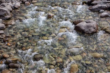 Azgın nehirdeki su. Taşların ve suyun güzel doğal arka planı. Berrak su ve hızlı nehir dokusu. Metin eklemek için arka plan. Turizm ve seyahat.