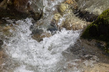 Azgın nehirdeki su. Taşların ve suyun güzel doğal arka planı. Berrak su ve hızlı nehir dokusu. Metin eklemek için arka plan. Turizm ve seyahat.