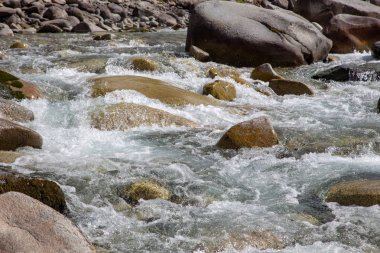 Azgın nehirdeki su. Taşların ve suyun güzel doğal arka planı. Berrak su ve hızlı nehir dokusu. Metin eklemek için arka plan. Turizm ve seyahat.
