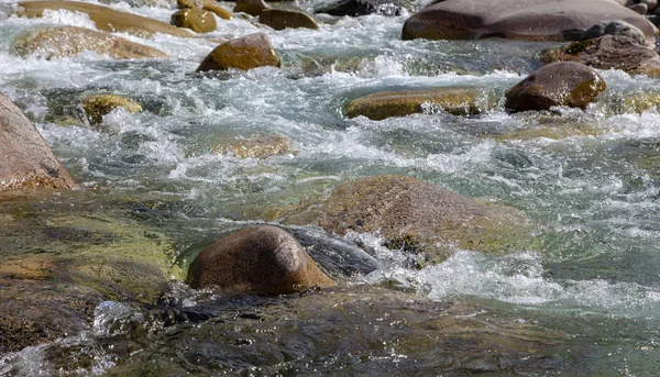 Vatten i berget Raging River. Vacker natur bakgrund av stenar och vatten. Konsistens av klart vatten och snabb flod. Bakgrund för att infoga text. Turism och resor. — Stockfoto