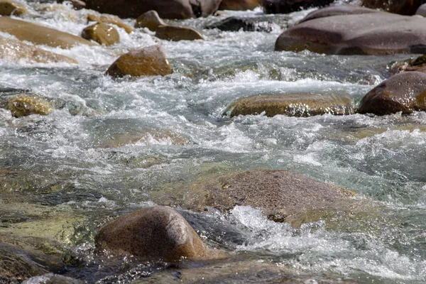 Vatten i berget Raging River. Vacker natur bakgrund av stenar och vatten. Konsistens av klart vatten och snabb flod. Bakgrund för att infoga text. Turism och resor. — Stockfoto