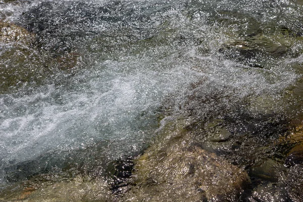 De l'eau dans la rivière montagneuse. Beau fond naturel de pierres et d'eau. Texture d'eau claire et rivière rapide. Contexte pour insérer du texte. Tourisme et voyages . — Photo