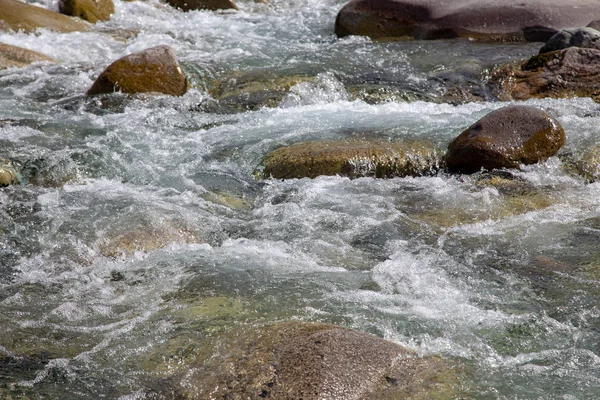 Vatten i berget Raging River. Vacker natur bakgrund av stenar och vatten. Konsistens av klart vatten och snabb flod. Bakgrund för att infoga text. Turism och resor. — Stockfoto