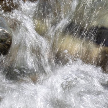 Azgın nehirdeki su. Taşların ve suyun güzel doğal arka planı. Berrak su ve hızlı nehir dokusu. Metin eklemek için arka plan. Turizm ve seyahat.