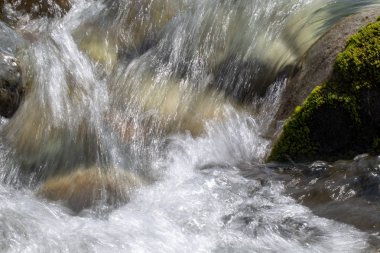 Azgın nehirdeki su. Taşların ve suyun güzel doğal arka planı. Berrak su ve hızlı nehir dokusu. Metin eklemek için arka plan. Turizm ve seyahat.