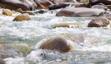 Azgın nehirdeki su. Taşların ve suyun güzel doğal arka planı. Berrak su ve hızlı nehir dokusu. Metin eklemek için arka plan. Turizm ve seyahat.