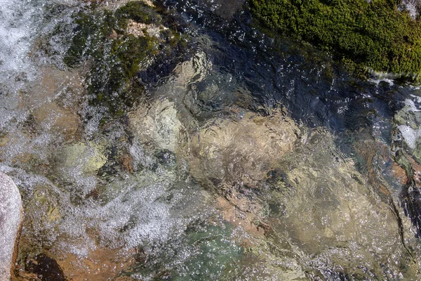 Azgın nehirdeki su. Taşların ve suyun güzel doğal arka planı. Berrak su ve hızlı nehir dokusu. Metin eklemek için arka plan. Turizm ve seyahat.