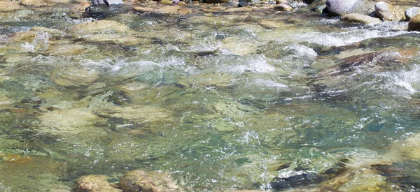 荒れ狂う川の水。石と水の美しい自然の背景。澄んだ水と速い川の質感。コピースペース付きの背景 — ストック写真