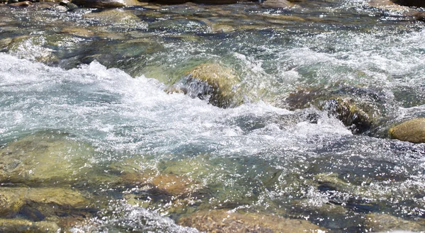 Vatten i berget Raging River. Vacker natur bakgrund av stenar och vatten. Konsistens av klart vatten och snabb flod. Bakgrund med kopierings utrymme — Stockfoto