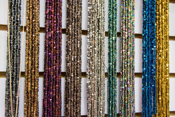 Multicolored handmade beads. Colorful background of the bead. Fashionable craft of women. Decoration of stones. Shop for creativity.