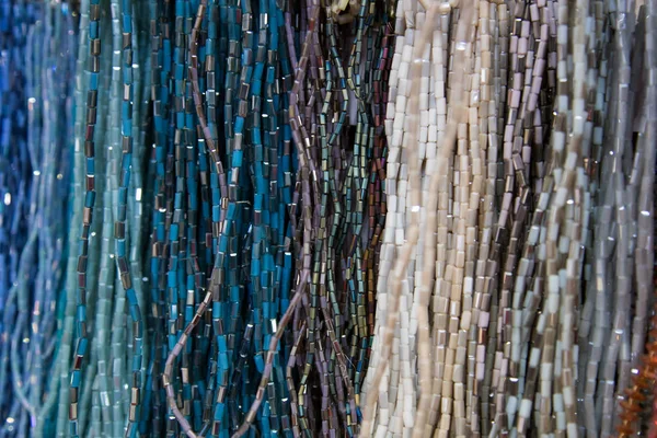 Mångfärgade handgjorda pärlor. Färgglad bakgrund av pärlan. Fashionabla hantverk av kvinnor. Dekoration av stenar. Handla för kreativitet. — Stockfoto