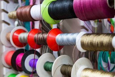 çok renkli iş parçacıkları ve şeritler. Şeritler ile makaralar satan mağaza için arka plan. dikiş ve yaratıcılık için malzemeler. Modaya uygun bir kadın zanaatı. Yaratıcılık için alışveriş yapın.