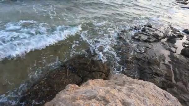 Casse la ligne. Vidéo statique belles vagues se brisent sur le rivage. Rochers et sable. L'Egypte, la mer Rouge .