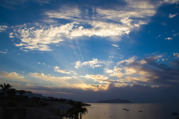 Salida del sol sobre el mar rojo. Hermoso cielo brillante con rayos de sol y nubes de la mañana. Mar y barcos. Vista de la isla Tiran. Egipto, Sharm El Sheikh. Turismo y viajes . — Foto de Stock