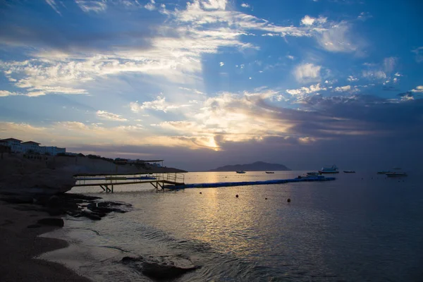 Salida del sol sobre el mar rojo. Hermoso cielo brillante con rayos de sol y nubes de la mañana. Mar y barcos. Vista de la isla Tiran. Egipto, Sharm El Sheikh. Turismo y viajes . — Foto de Stock