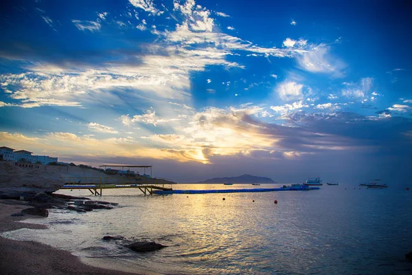 Salida del sol sobre el mar rojo. Hermoso cielo brillante con rayos de sol y nubes de la mañana. Mar y barcos. Vista de la isla Tiran. Egipto, Sharm El Sheikh. Turismo y viajes . — Foto de Stock