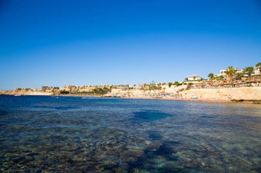 Şarm El Şeyh, Mısır - 18 Mart 2019: Kızıldeniz Sahili, Concord Hotel. Şemsiye, şezlong ve palmiye ağaçları ile plaj. Arka plan turizmi ve seyahat. Dinlenme ve tatil.