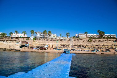 Şarm El Şeyh, Mısır - 18 Mart 2019: Kızıldeniz Sahili, Concord Hotel. Şemsiye, şezlong ve palmiye ağaçları ile plaj. Arka plan turizmi ve seyahat. Dinlenme ve tatil.