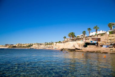 Şarm El Şeyh, Mısır - 18 Mart 2019: Kızıldeniz Sahili, Concord Hotel. Şemsiye, şezlong ve palmiye ağaçları ile plaj. Arka plan turizmi ve seyahat. Dinlenme ve tatil.