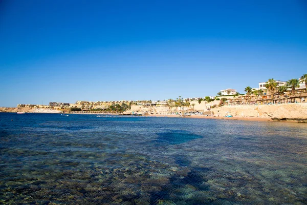 Şarm El Şeyh, Mısır - 18 Mart 2019: Kızıldeniz Sahili, Concord Hotel. Şemsiye, şezlong ve palmiye ağaçları ile plaj. Arka plan turizmi ve seyahat. Dinlenme ve tatil.