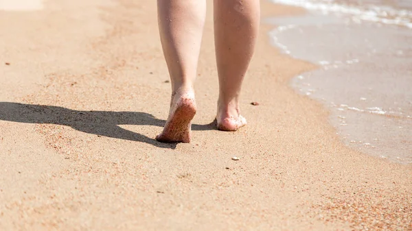 Closeup a mezítláb a strandon. Séta a homokon a víz szélén. Vakáció és utazási koncepció. Női lábak. Kozmetikai és testápolás. Beach Travel-nő lábak homok strand — Stock Fotó