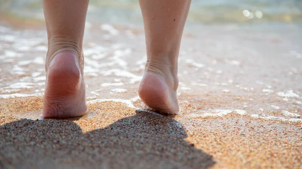 Closeup of bare feet on the beach. Walking on the sand at the water's edge. Vacation and travel concept. Women's legs. Cosmetics and body care. Beach travel - woman legs on sand beach — Stock Photo, Image