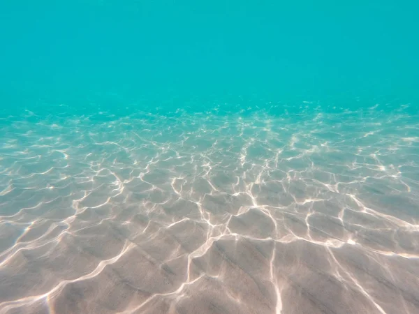 Víz alatti háttér homokos tengerfenéken. Gyönyörű textúra a tenger és az óceán vizén. Tiszta vízszerkezet. — Stock Fotó