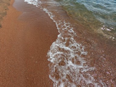 Kumlu alt ile berrak su dokusu. Deniz kıyısında veya okyanusta dalga dalga. Doğal doğal arka plan.