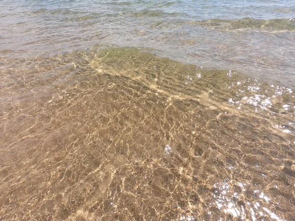 De textuur van helder water met zanderige bodem. Natuurlijke natuurlijke achtergrond. Toerisme en reizen — Stockfoto