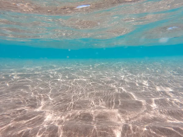 Underwater background with sandy sea bottom. Beautiful texture of the sea and ocean water. Pure water texture. — Stock Photo, Image