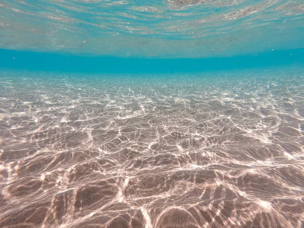 Underwater background with sandy sea bottom. Beautiful texture of the sea and ocean water. Pure water texture. — Stock Photo, Image