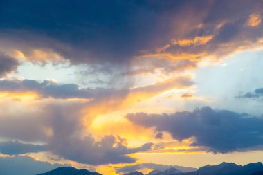 yumuşak günbatımı gökyüzü. pembe ve altın bulutlar. Yüksek dağlar. Doğal arka plan.