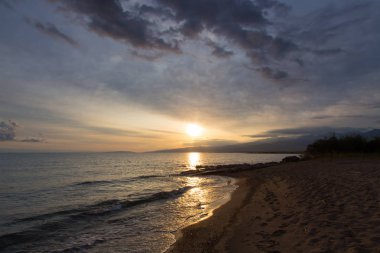 Dağlardaki bir gölde güzel gün batımı. Kırgızistan, İssyk-Kul Gölü. Parlak gökyüzü, sıcak renklerde arka plan.