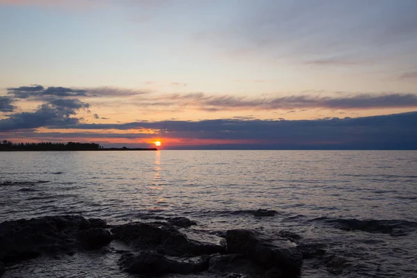 Wunderschöner Sonnenuntergang an einem See in den Bergen. Kyrgyzstan, Issyk-kul-See. heller Himmel, Hintergrund in warmen Farben. — Stockfoto