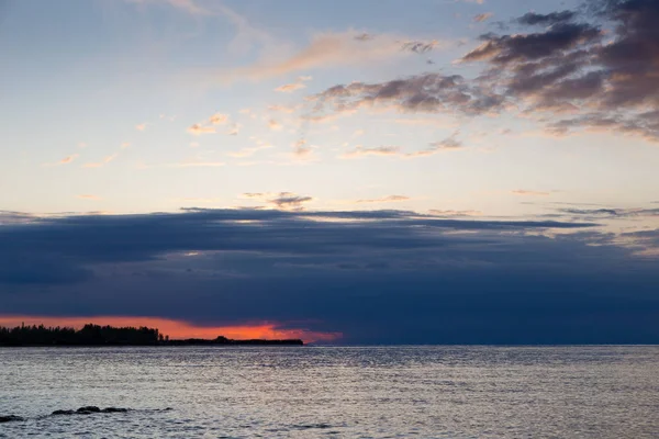 Belo pôr-do-sol num lago nas montanhas. Quirguizistão, Lago Issyk-Kul. Céu brilhante, fundo em cores quentes . — Fotografia de Stock