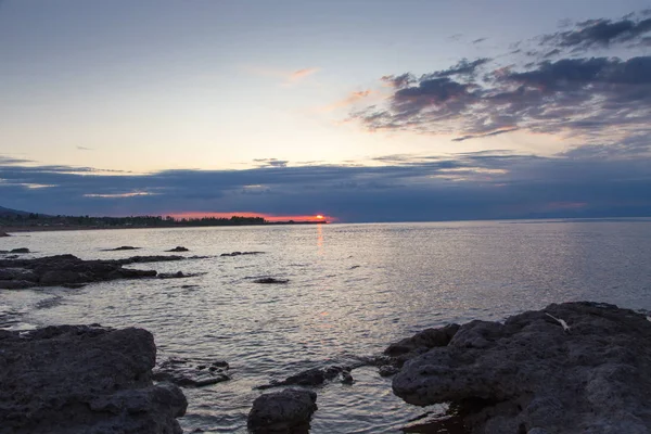 Belo pôr-do-sol num lago nas montanhas. Quirguizistão, Lago Issyk-Kul. Céu brilhante, fundo em cores quentes . — Fotografia de Stock