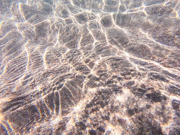 Klares Wasser. Unterwasserhintergrund mit sandigem Meeresgrund. schöne Textur des Meeres und Ozeanwassers. — Stockfoto