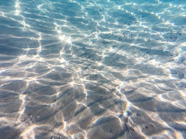 Agua clara. fondo submarino con fondo marino arenoso. Hermosa textura del mar y el agua del océano . —  Fotos de Stock