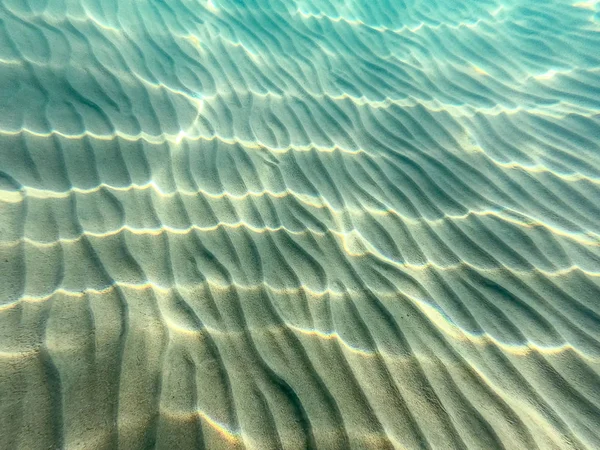 De l'eau claire. fond sous-marin avec fond de mer sablonneux. Belle texture de la mer et de l'eau de mer . — Photo