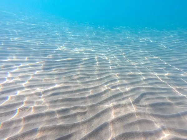 De l'eau claire. fond sous-marin avec fond de mer sablonneux. Belle texture de la mer et de l'eau de mer . — Photo