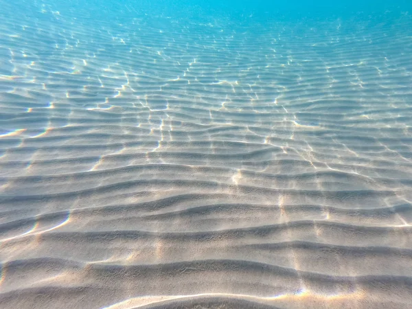Helder water. onderwater achtergrond met zanderige zeebodem. Prachtige textuur van de zee en Oceaan water. — Stockfoto